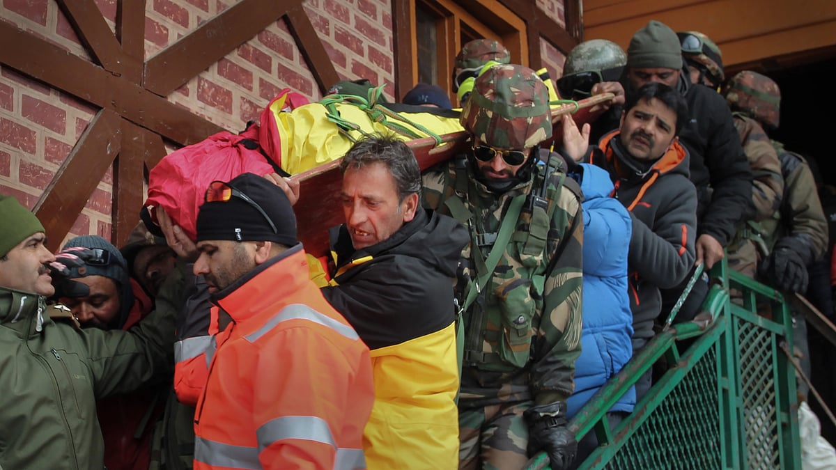 <div class="paragraphs"><p>Police and Army personnel carry a body of a foreign national after an avalanche hit ski slopes that left 2 persons dead, in Gulmarg, Wednesday, 1 February.</p></div>