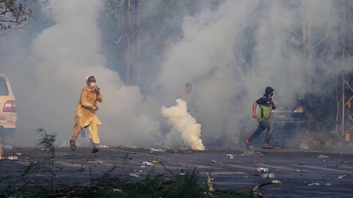 <div class="paragraphs"><p>Supporters of former Prime Minister Imran Khan run for cover after riot police officers fire tear gas to disperse them during clashes in Pakistan's Lahore.</p></div>