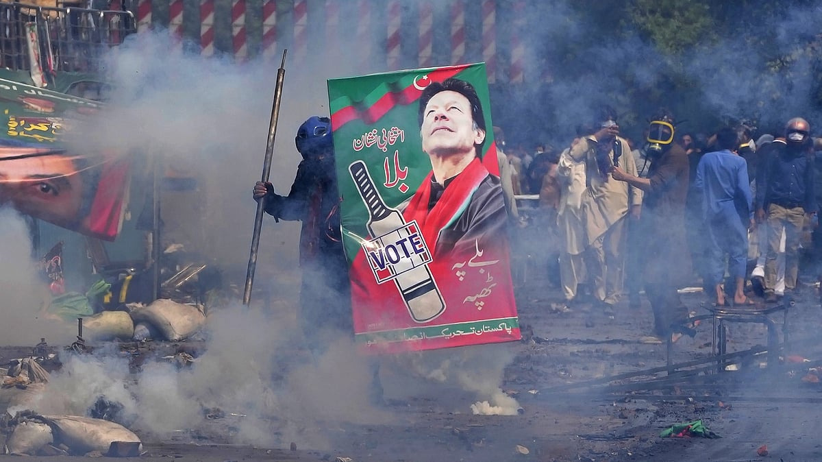 <div class="paragraphs"><p>Supporters of former Prime Minister Imran Khan take cover after riot police officers fire tear gas to disperse them during clashes, in Lahore.</p></div>