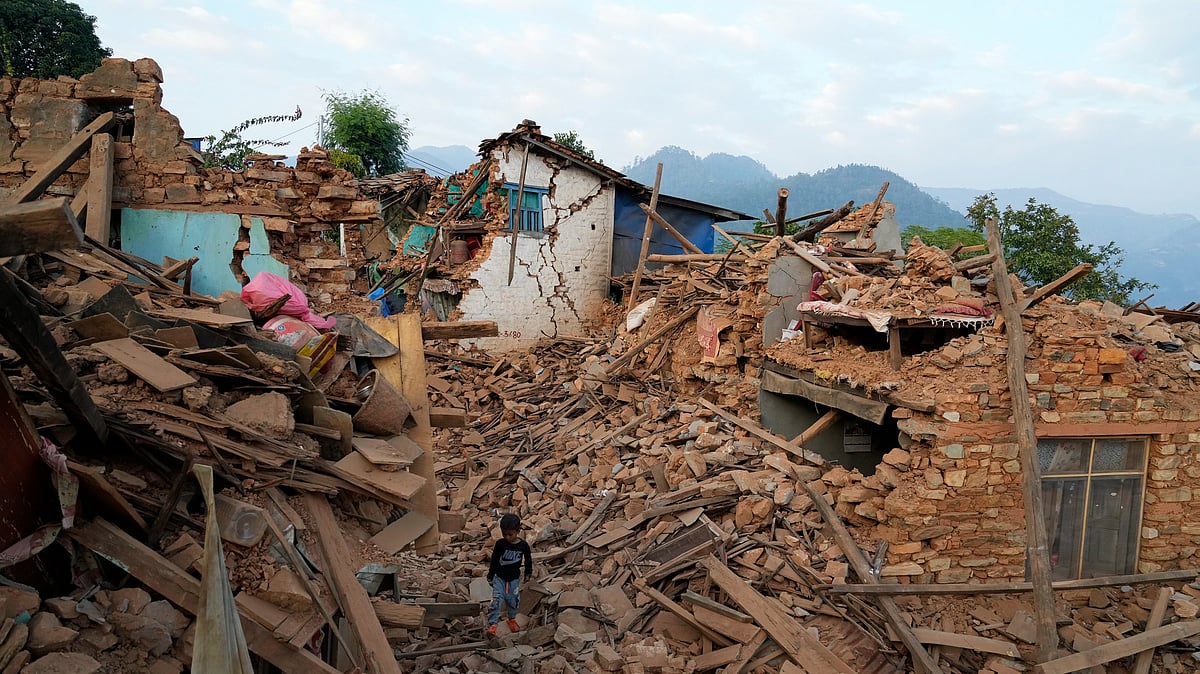 <div class="paragraphs"><p>A young boy walks past earthquake damaged houses in Jajarkot district, northwestern on&nbsp; 5 November.</p></div>