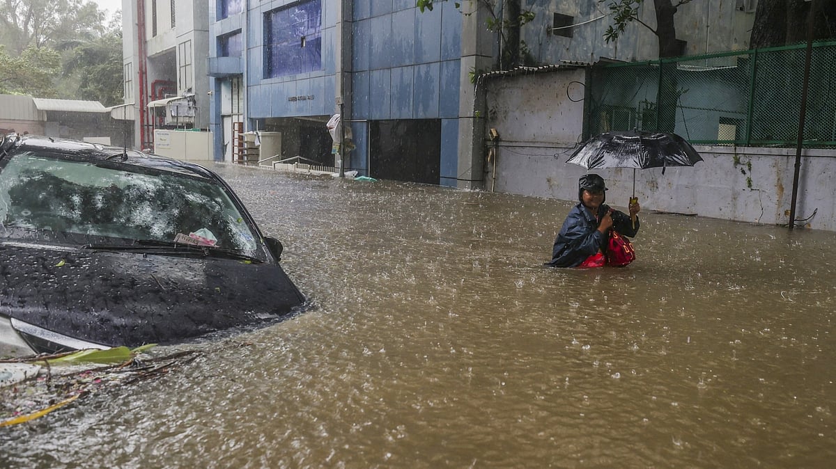 <div class="paragraphs"><p>A person wades through a waterlogged road during heavy rain owing to Cyclone Michaung, in Chennai on Monday, 4 December.</p></div>