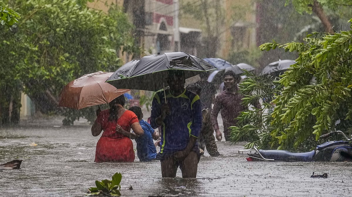 <div class="paragraphs"><p>People wade through a waterlogged road during heavy rain owing to Cyclone Michaung, in Chennai on Monday, 4 December. </p></div>
