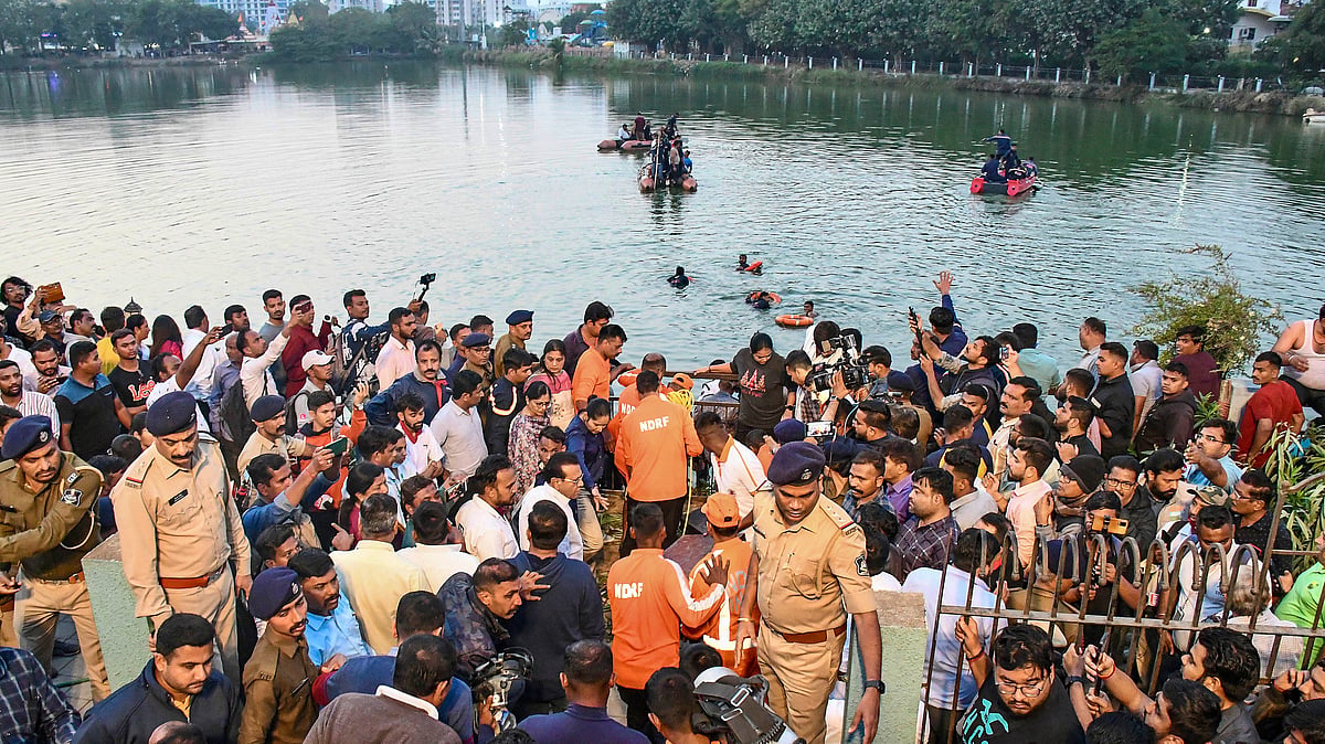 <div class="paragraphs"><p>People gather during a rescue and search operation after a boat overturned in a lake in Vadodara</p></div>