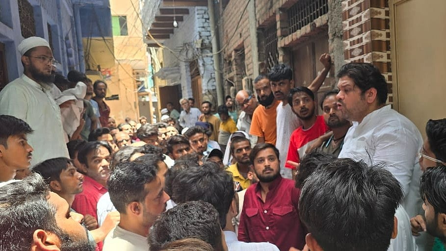 <div class="paragraphs"><p>(Samajwadi Party workers gather outside the house of the victim)</p></div>