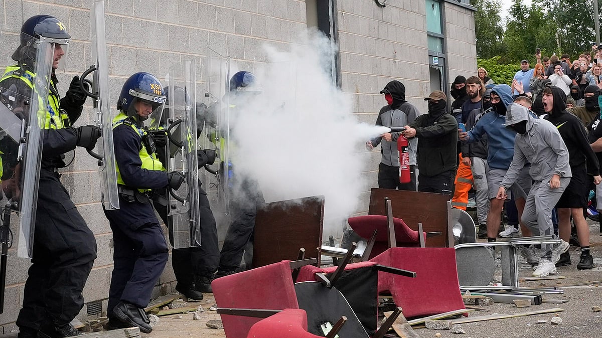 <div class="paragraphs"><p>A protester uses a fire extinguisher on police officers as trouble flares during an anti-immigration protest outside the Holiday Inn Express in Rotherham, England on Sunday, 4 August. </p></div>