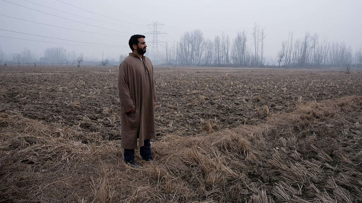 <div class="paragraphs"><p>A farmer staring into the vast rice field that is likely to be turned into a satellite township near the Srinagar Ring Road project.</p></div>