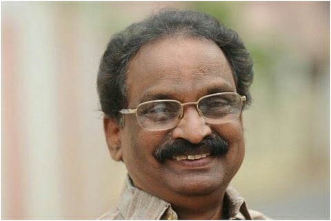 Kerala Law Minister AK Balan smiling for the camera 