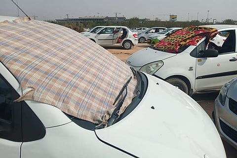 Taxis covered in cloth during summer outside Hyderabad airport