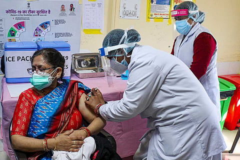A woman in Ajmer being administered COVID vaccine by a health worker 
