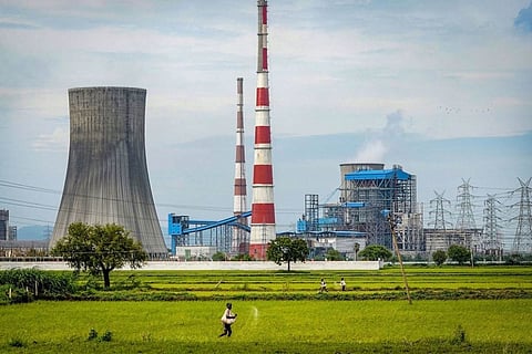 Vijayawada: A farmer throws seed pesticides at a paddy field near the Dr. Narla Tata Rao Thermal Power Plant, in Vijayawada,