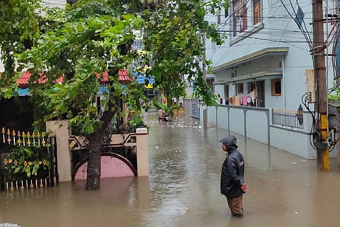 A policeman standing in knee deep water in a flooded street in Andhra Pradesh after heavy rains