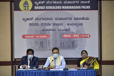 Three seated BBMP officials announcing the 2021-22 budget