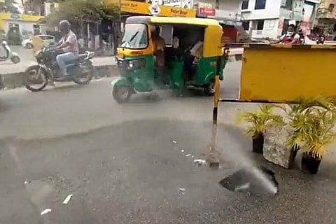 Water spewing out of the sinkhole on the road