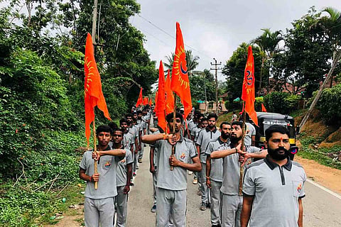 The members of Bajrang Dal seen marching with their flag during the arms training event in Karnataka