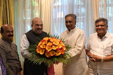 Basavaraj Horatti and Amit Shah holding a bouquet as Basavaraj Horatti joins BJP