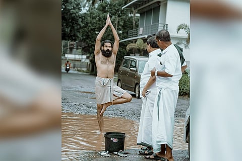 A youth standing in a yoga pose in a pothole in Kerala's Malappuram