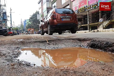 A large pothole filled with rainwater on a Bengaluru road
