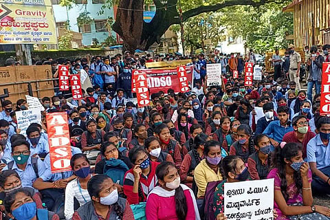 Several second PU students sitting at Mysore Bank Circle during protest
