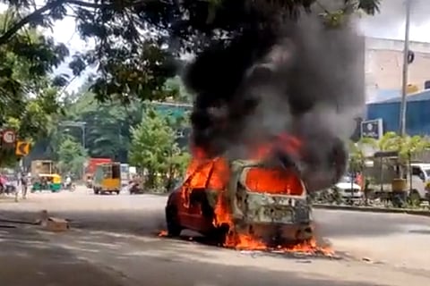 A car set on fire by Youth Congress workers in Bengaluru