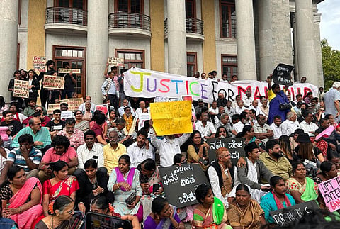 people sitting in protest in bengaluru town hall
