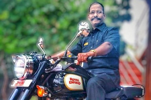 50-year-old special sub-inspector S Boominathan sitting in a bike.