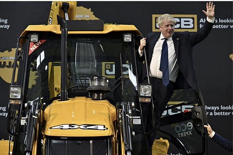 Boris Johnson sitting on a JCB