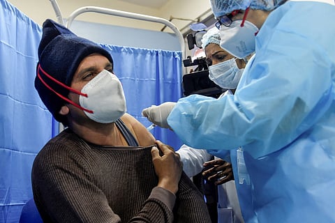 A man being vaccinated by a healthcare worker