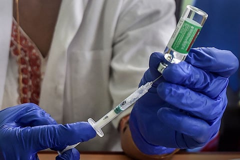 Health worker drawing COVID-19 vaccine from a vial