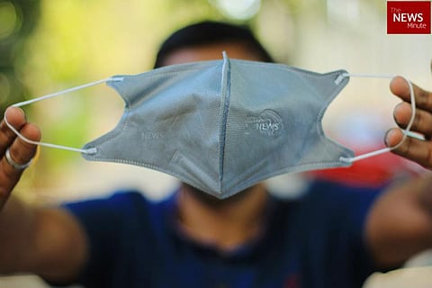 A person holding up a face mask