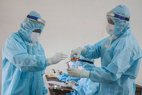 Medics with swab samples for COVID test