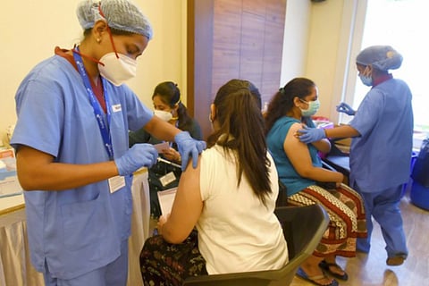 Two women receiving COVID-19 vaccine shots