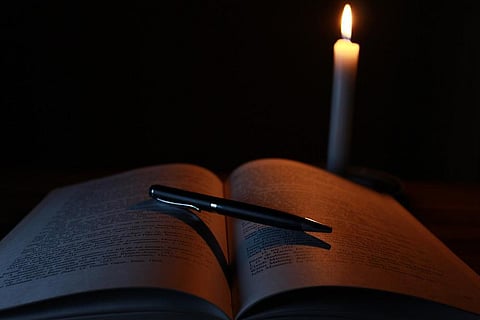 Tamil Nadu power cuts: A book and a pen kept in front of a candle