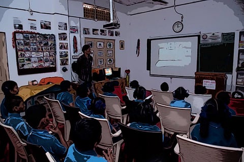 Students sitting in a classroom with teacher standing 