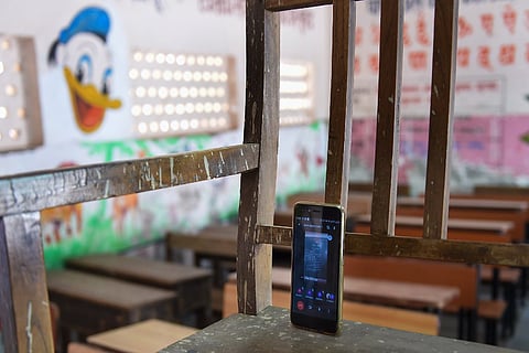 A phone kept on a chair by a teacher as she takes online classes of class 9 students at Dharavi in Mumbai