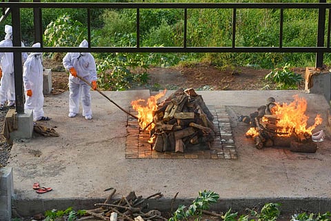 Health officials light pyres for cremation