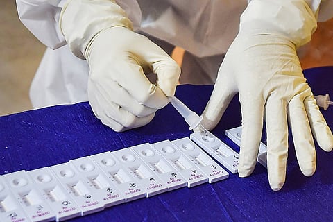 A health worker conducting coronavirus test. Only a pair of hands wearing gloves are seen in the photo.