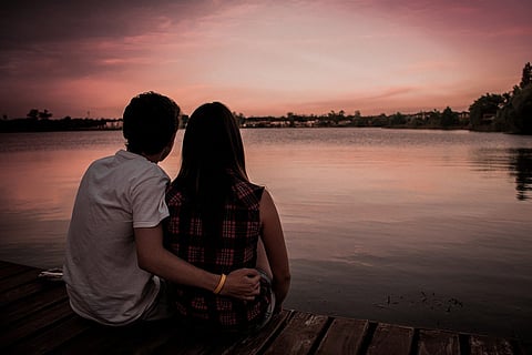 Couple sitting by lake