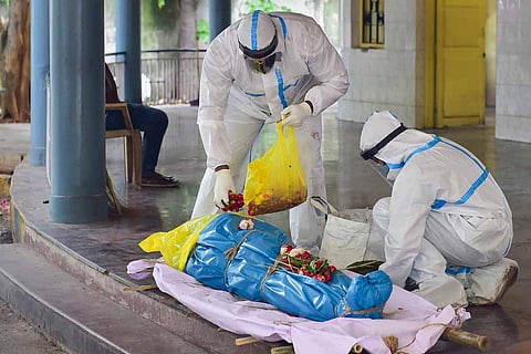 Health workers preparing to cremate COVID-19 victim