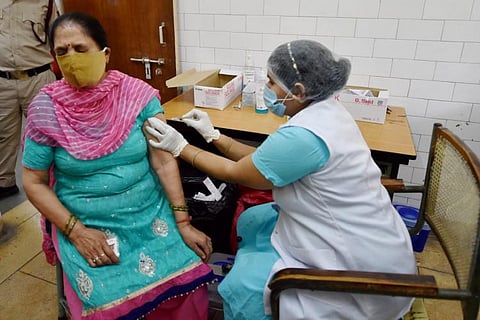 A woman receiving COVID-19 vaccine from healthcare worker