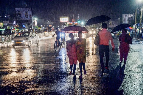 Commuters walk on the street amid rain in Ranchi, Sunday, September 26, 2021. 