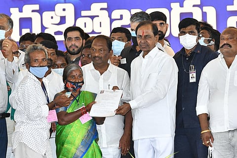 Chief Minister KCR handing over a cheque to a beneficiary