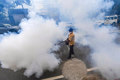 A civic worker fumigates an area as part of preventive measures against mosquito-borne disease dengue