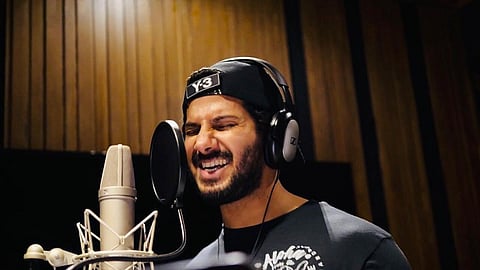 Dulquer Salmaan is seen recording a song in a studio. 