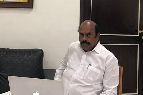 Tamil Nadu Highways Minister EV Velu sits before a mac laptop 