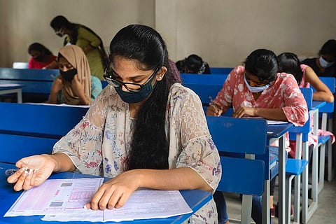 Student with mask writing exams 