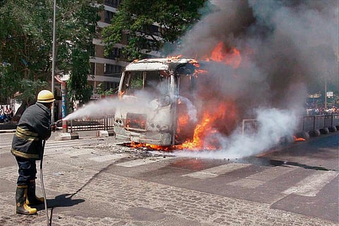 A fireman dousing a vehicle caught on fire