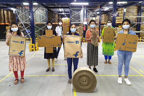 Individuals pose with Flipkart plastic-free packaging