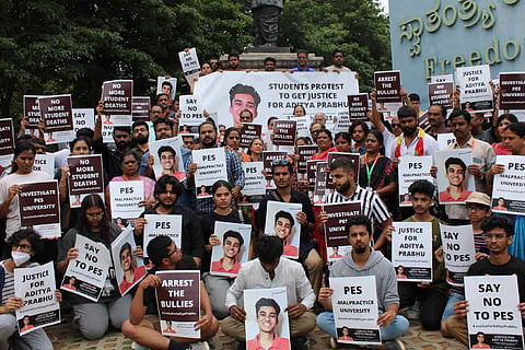Protesters holding placards with Aditya's photo