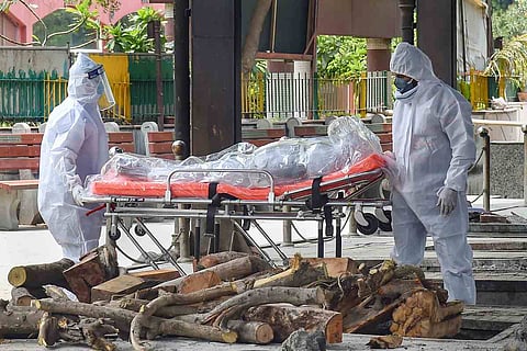 People in PPE carrying a COVID-19 victim's body
