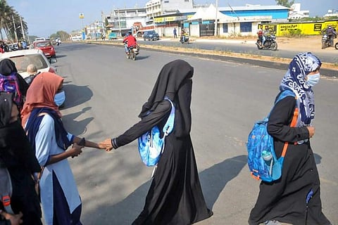 Girls wearing hijab and burqa crossing a road 